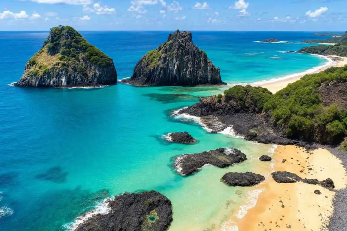 Vista aérea de Fernando de Noronha com mar turquesa e o Morro Dois Irmãos